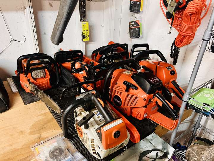 A row of professional chainsaws lined up on a workbench in Myrtle Beach, SC