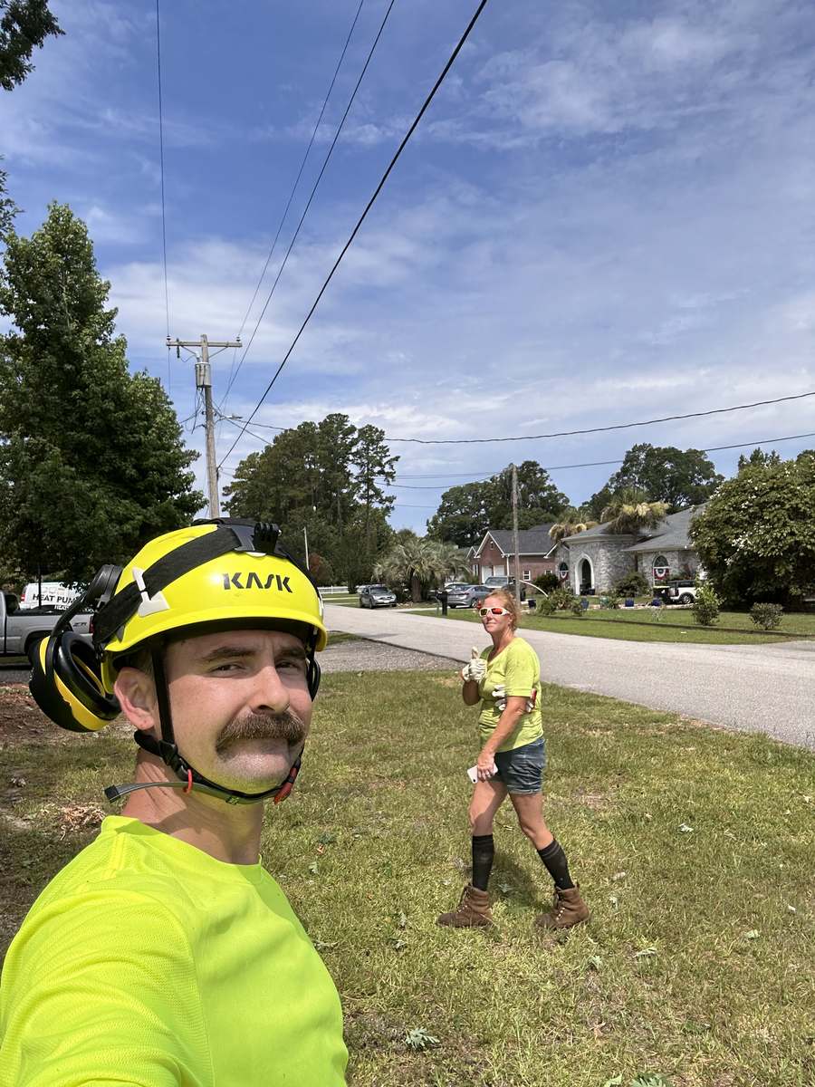 Corey in a hi-vis shirt and helmet at a jobsite with a crew member behind him in Myrtle Beach, SC